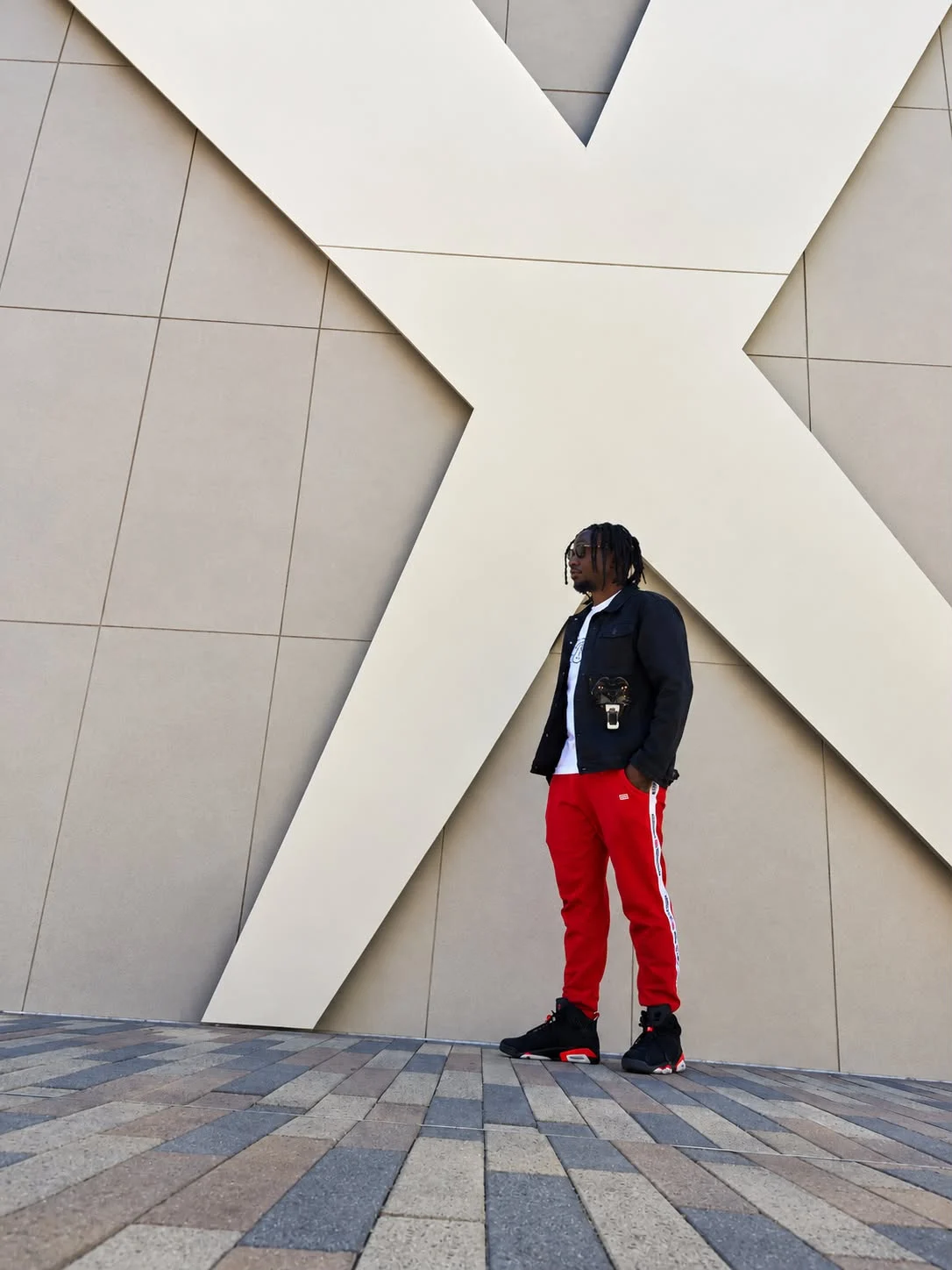 Machapaa standing in front of a modern geometric wall